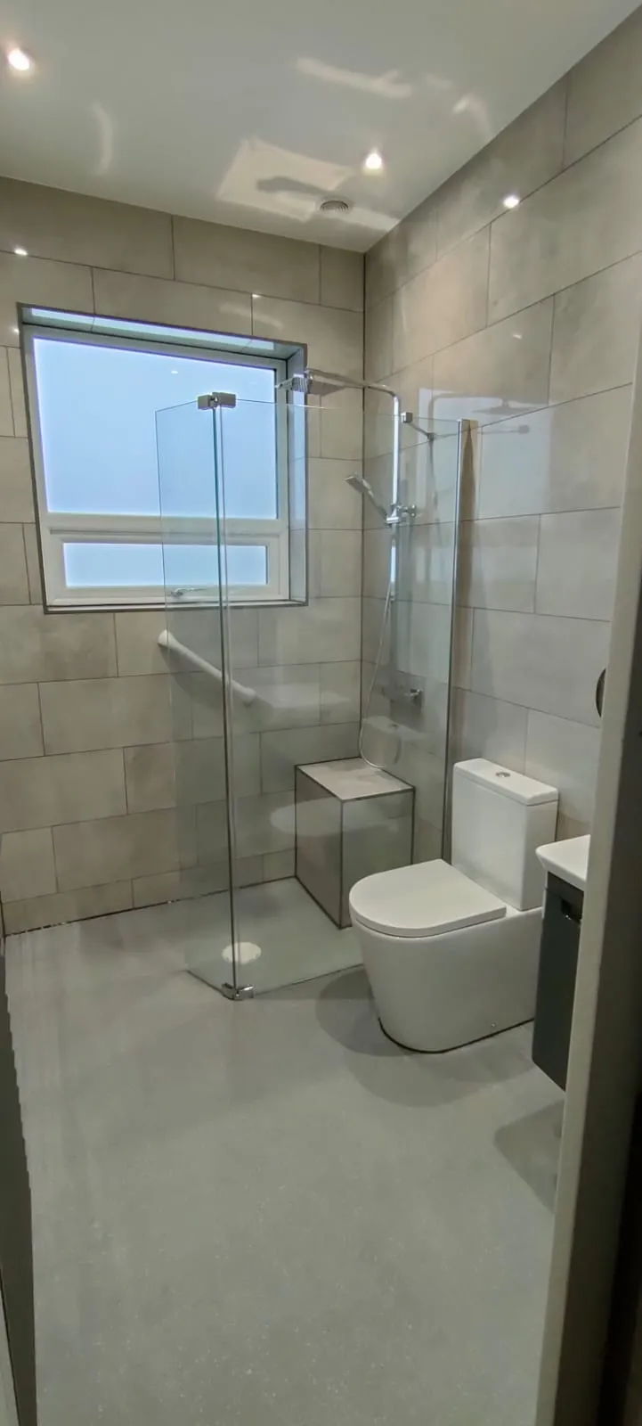 a bathroom with a toilet, shower, and sink