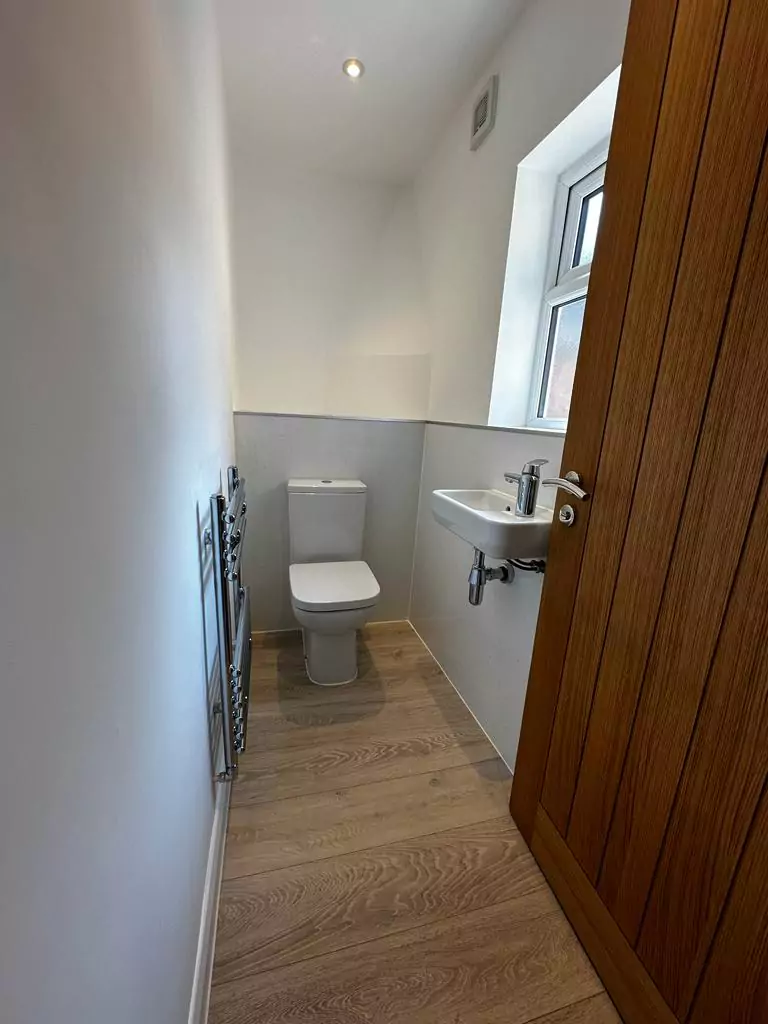 a bathroom with a toilet, sink, and radiator